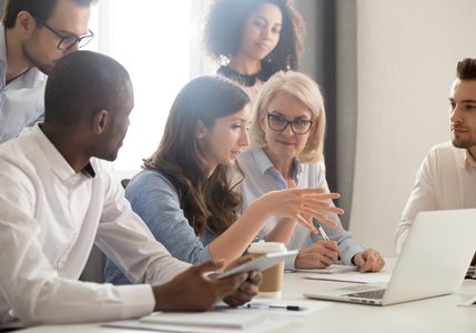 119154625-young-female-mentor-leader-coach-teaching-employees-group-analyzing-online-project-explaining-busine 119154625-young-female-mentor-leader-coach-teaching-employees-group-analyzing-online-project-explaining-busine